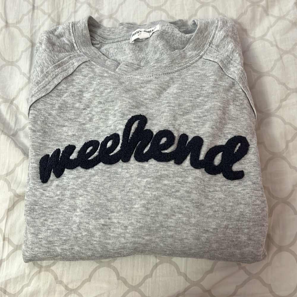 A gray light sweatshirt w/ “Weekend” written on front. Size large.